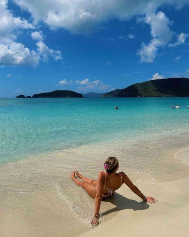 girl sitting on beautiful white sand beach