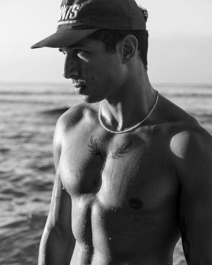 black and white image of a muscular guy at beach