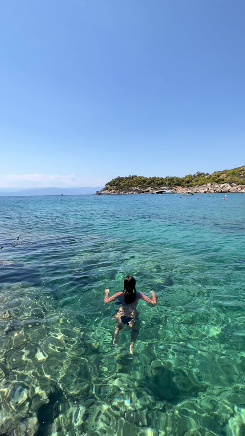 Girl swimming in crystal clear blue water